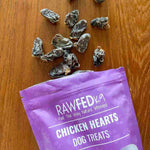 RawFedK9 dehydrated chicken hearts spilling out of their branded treat bag, highlighting natural, protein-rich single-ingredient treats for dogs.