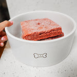 RawFedK9 PMR patties served in a white bowl, highlighting a complete and balanced raw meal made from muscle meat, bone, and organ for dogs.
