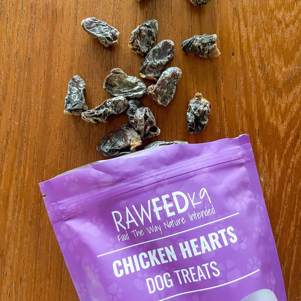 RawFedK9 dehydrated chicken hearts spilling out of their branded treat bag, highlighting natural, protein-rich single-ingredient treats for dogs.