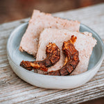 RawFedK9 dehydrated chicken necks stacked on top of PMR patties.