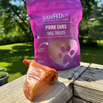 RawFedK9 dehydrated pig ears displayed next to their branded treat bag, showcasing natural, long-lasting single-ingredient chews for dogs.
